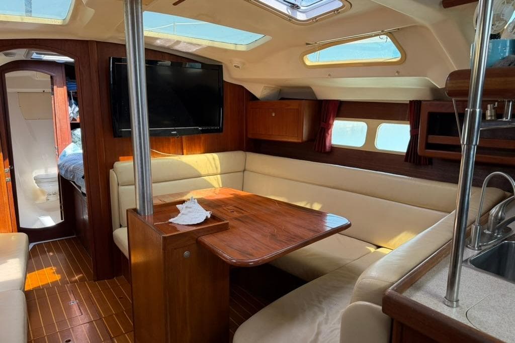 Luxurious interior of a 2002 Hunter 410 sailboat with wood finishes and cozy seating.