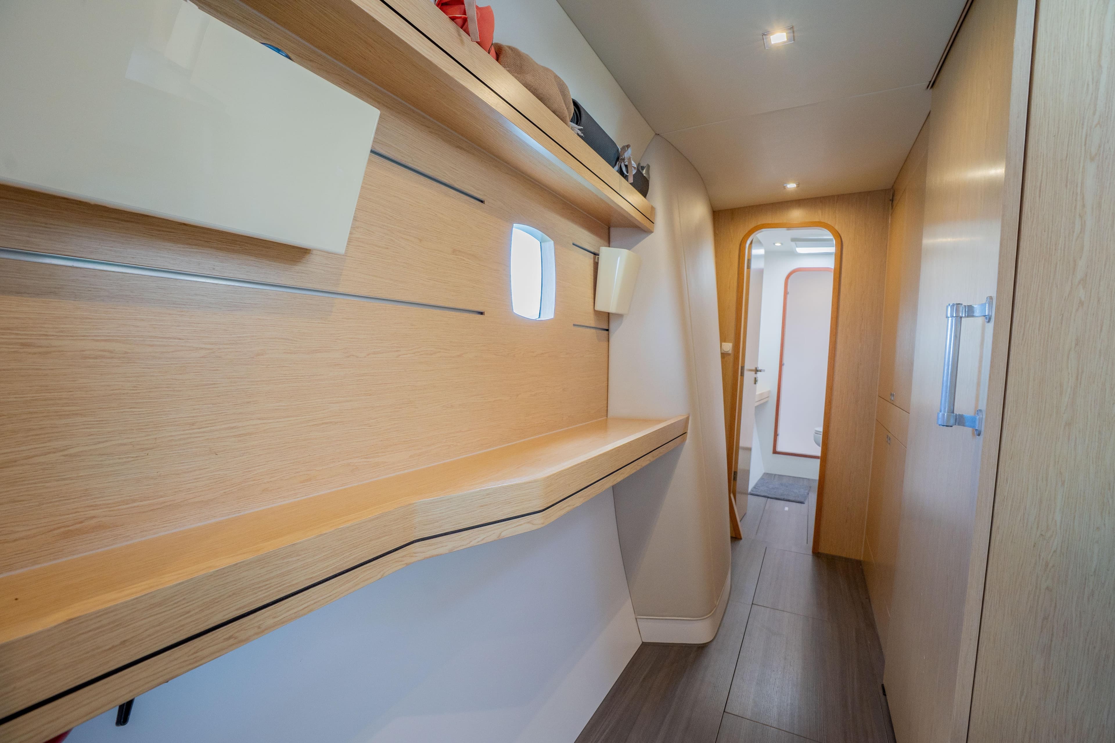 2020 Outremer 51 yacht interior hallway with modern wooden design and shelving.