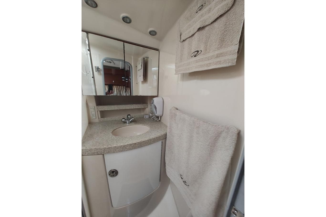 Bathroom interior of 2006 Regal Commodore 3560 IO yacht, featuring sink and towels.