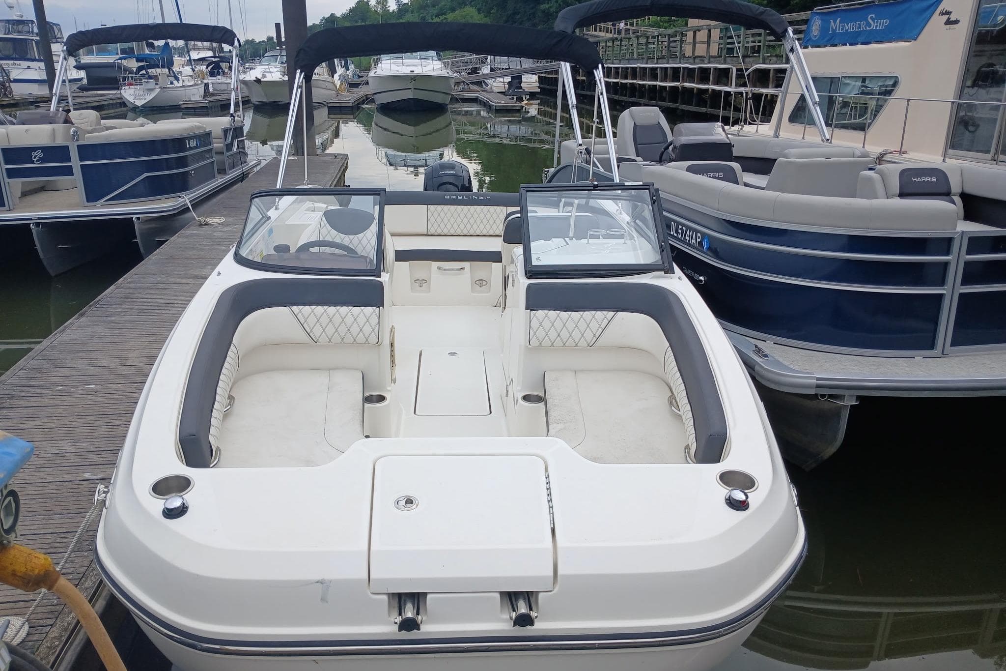 2023 Bayliner DX 2200 boat docked at marina, featuring spacious seating and modern design.