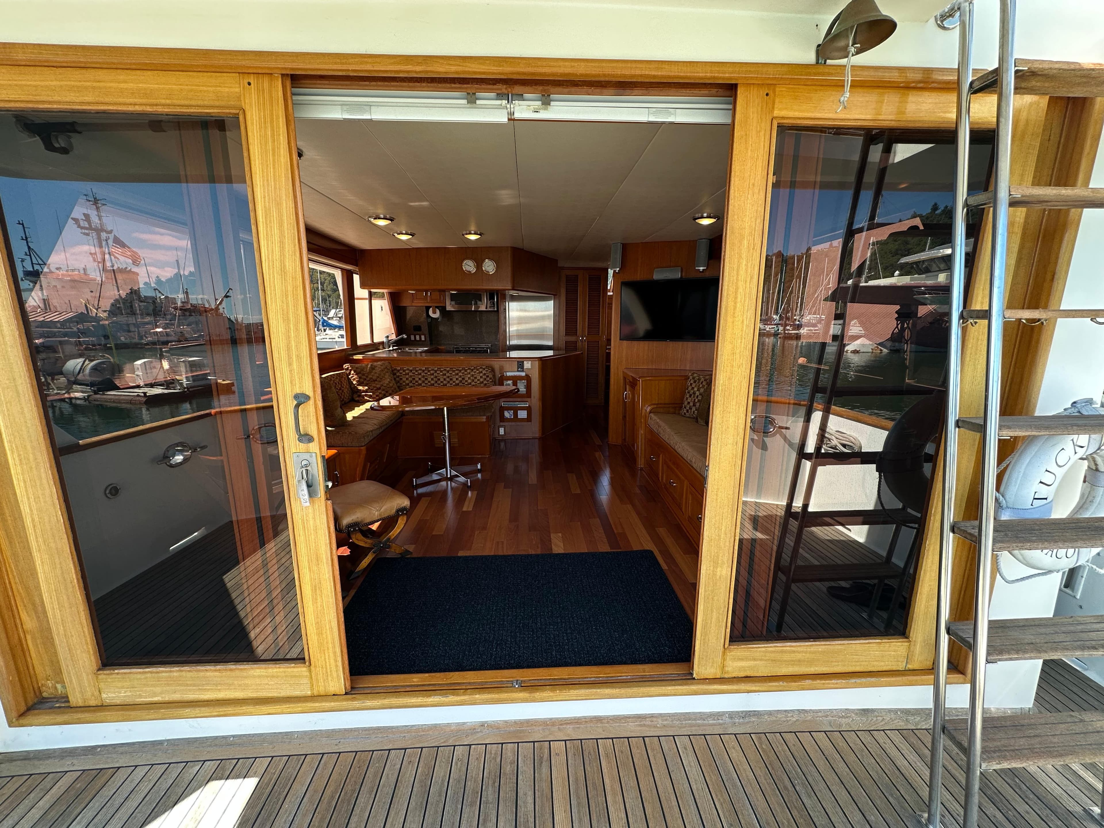 1985 Ocean Alexander Pilothouse interior with wooden flooring, kitchen, and seating area.