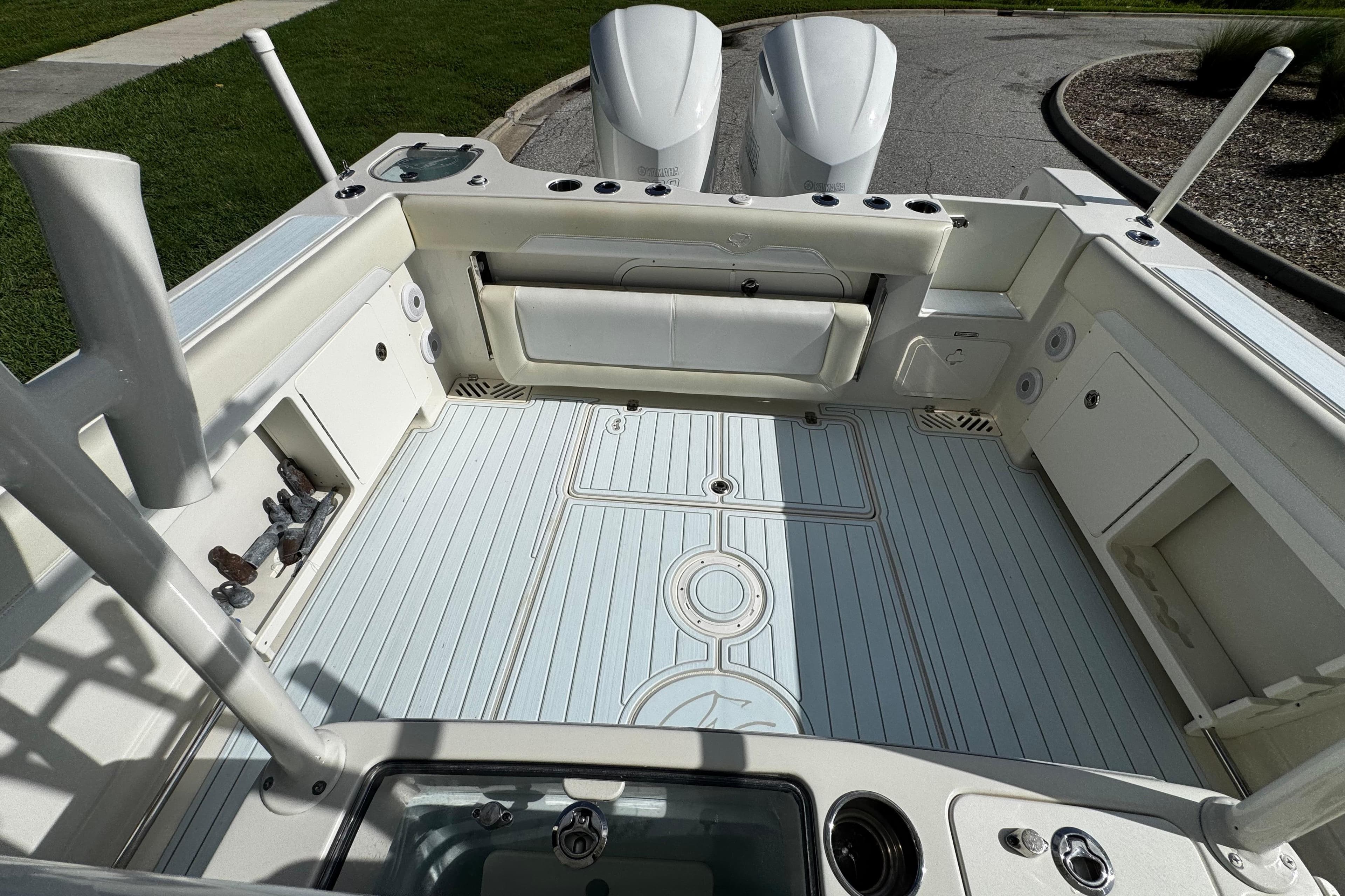 2015 Sailfish 320 CC boat deck with twin engines, spacious layout, and storage compartments.