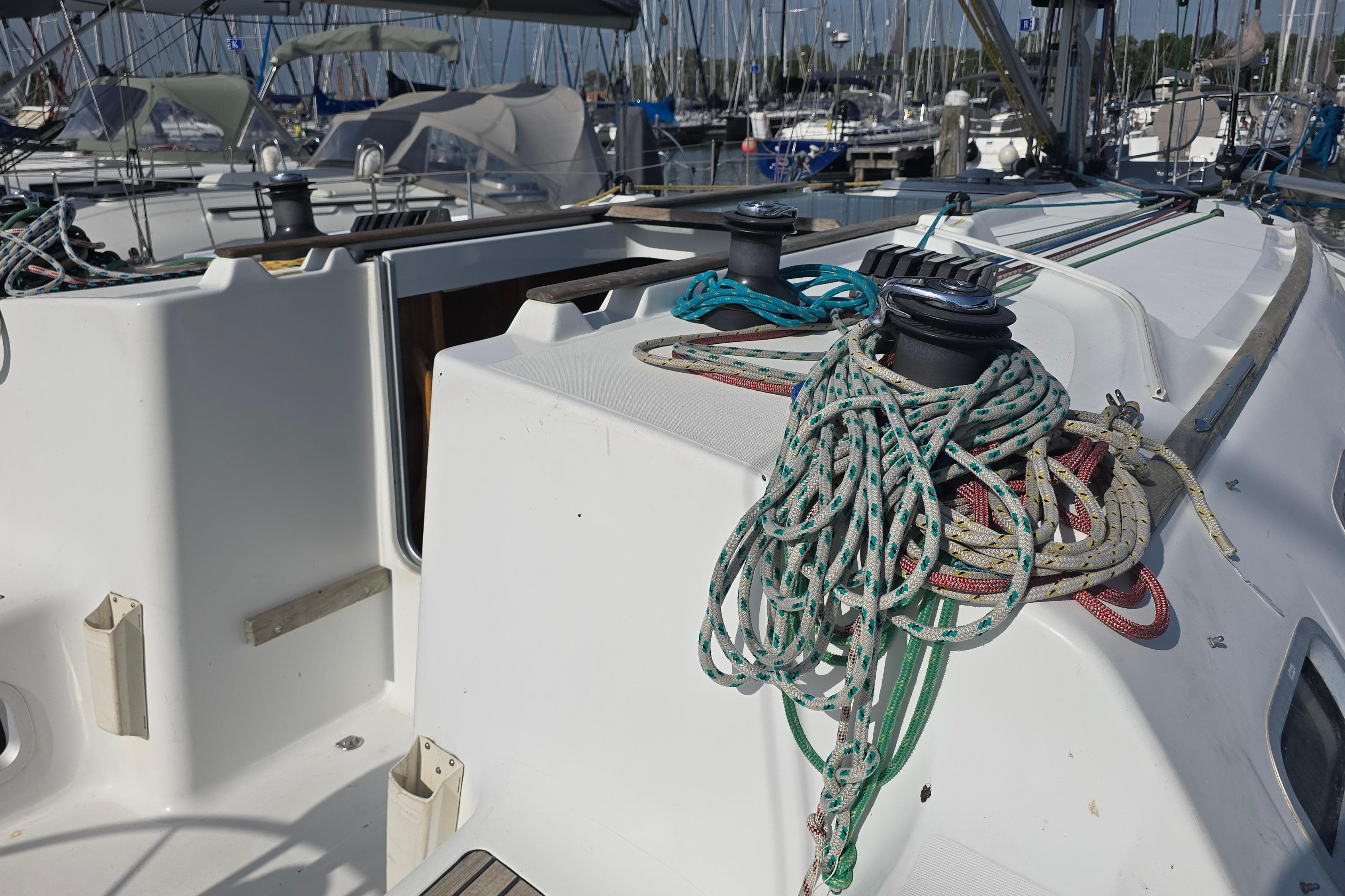 Jeanneau Sun Fast 37 sailboat deck with ropes, winches, and marina background, 2002 model.