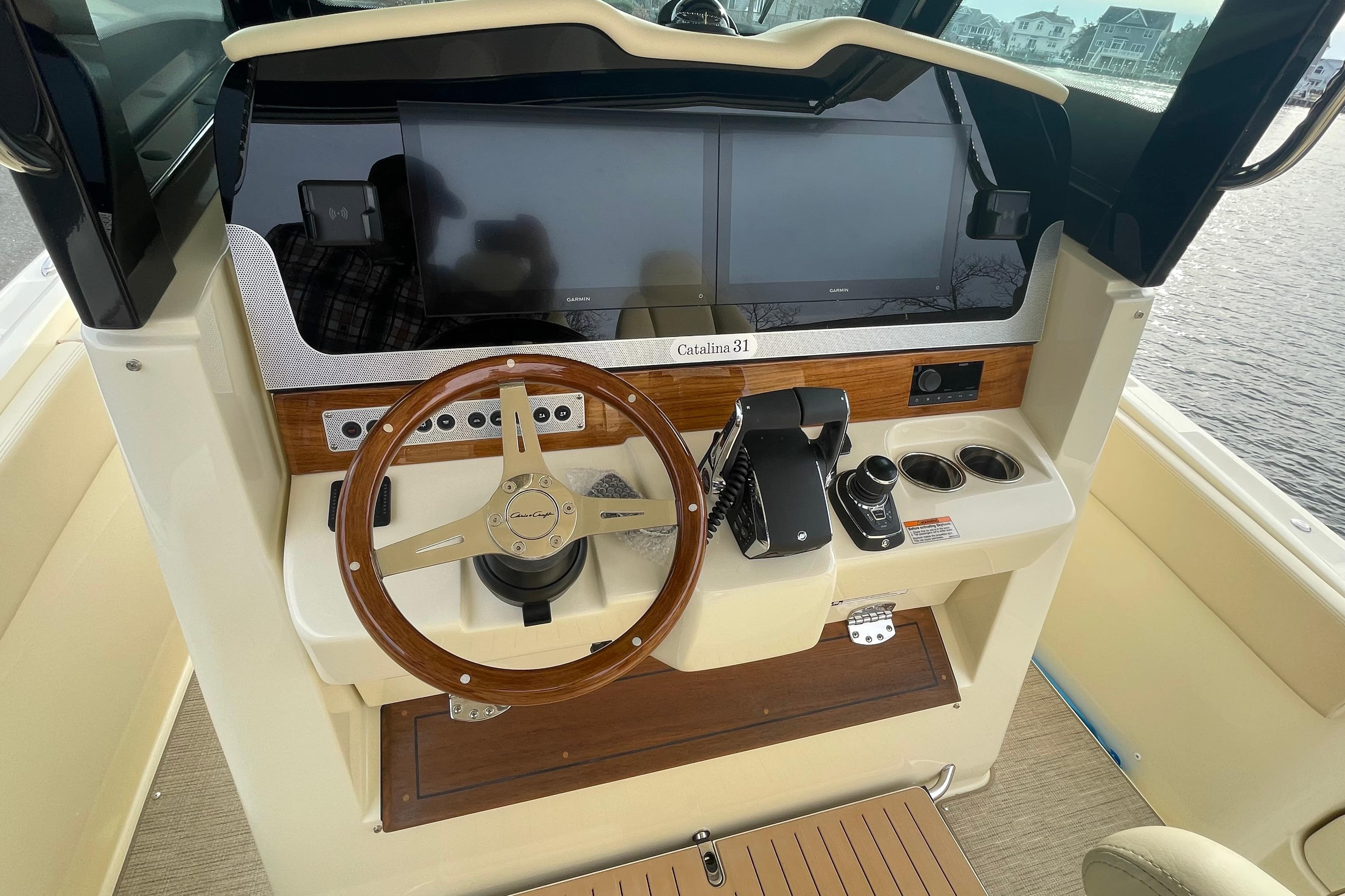 2026 Chris-Craft 310 Catalina helm with wooden steering wheel and modern controls.