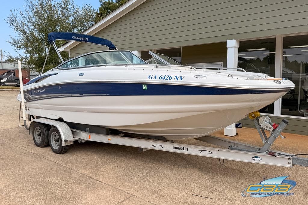 2004 Crownline 240 EX boat on trailer, parked outside a building.