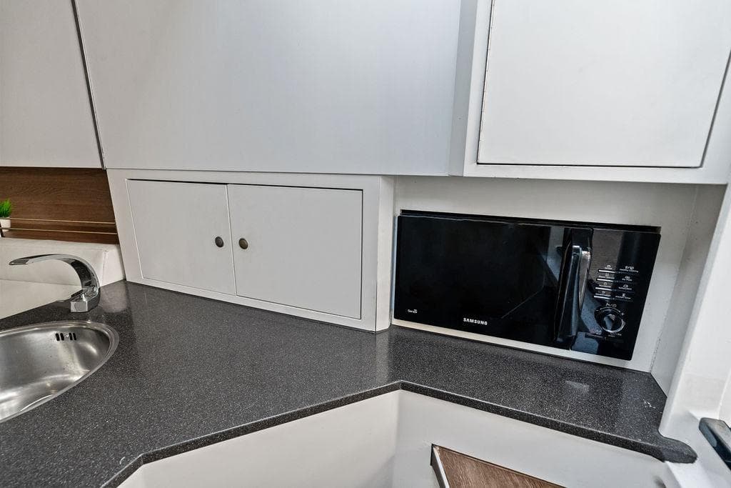 Modern kitchen area in 2016 Vanquish Yachts VQ48 with microwave and sink.