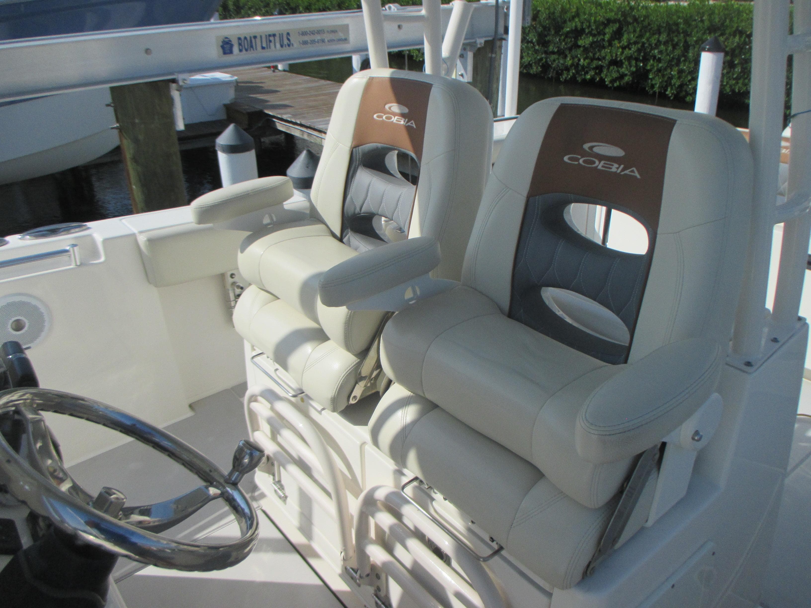 2018 Cobia 301 Center Console boat seats with steering wheel, showcasing luxury and comfort.