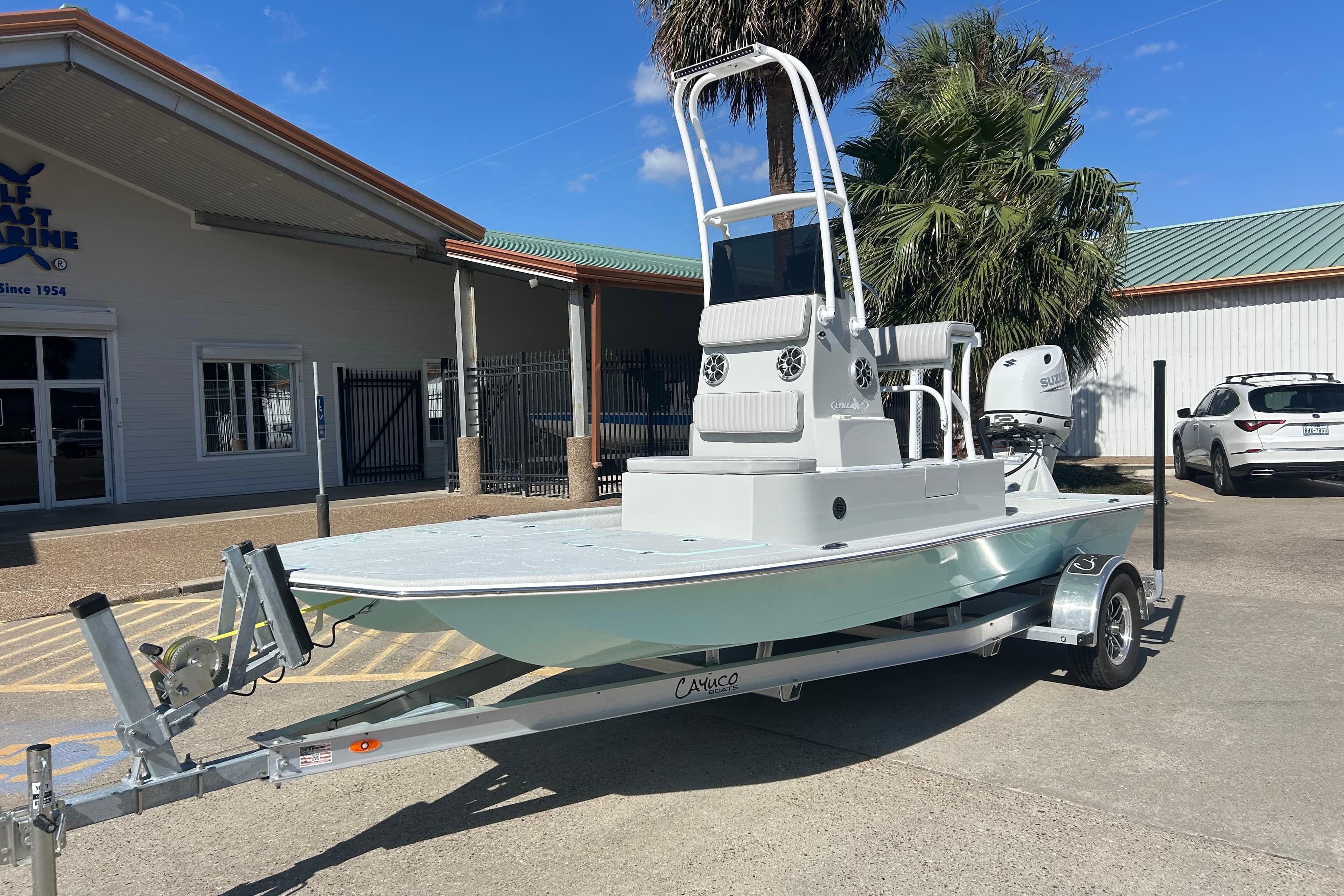 2026 Cayuco Boats Lynx 18 on trailer, parked outside a marine dealership.