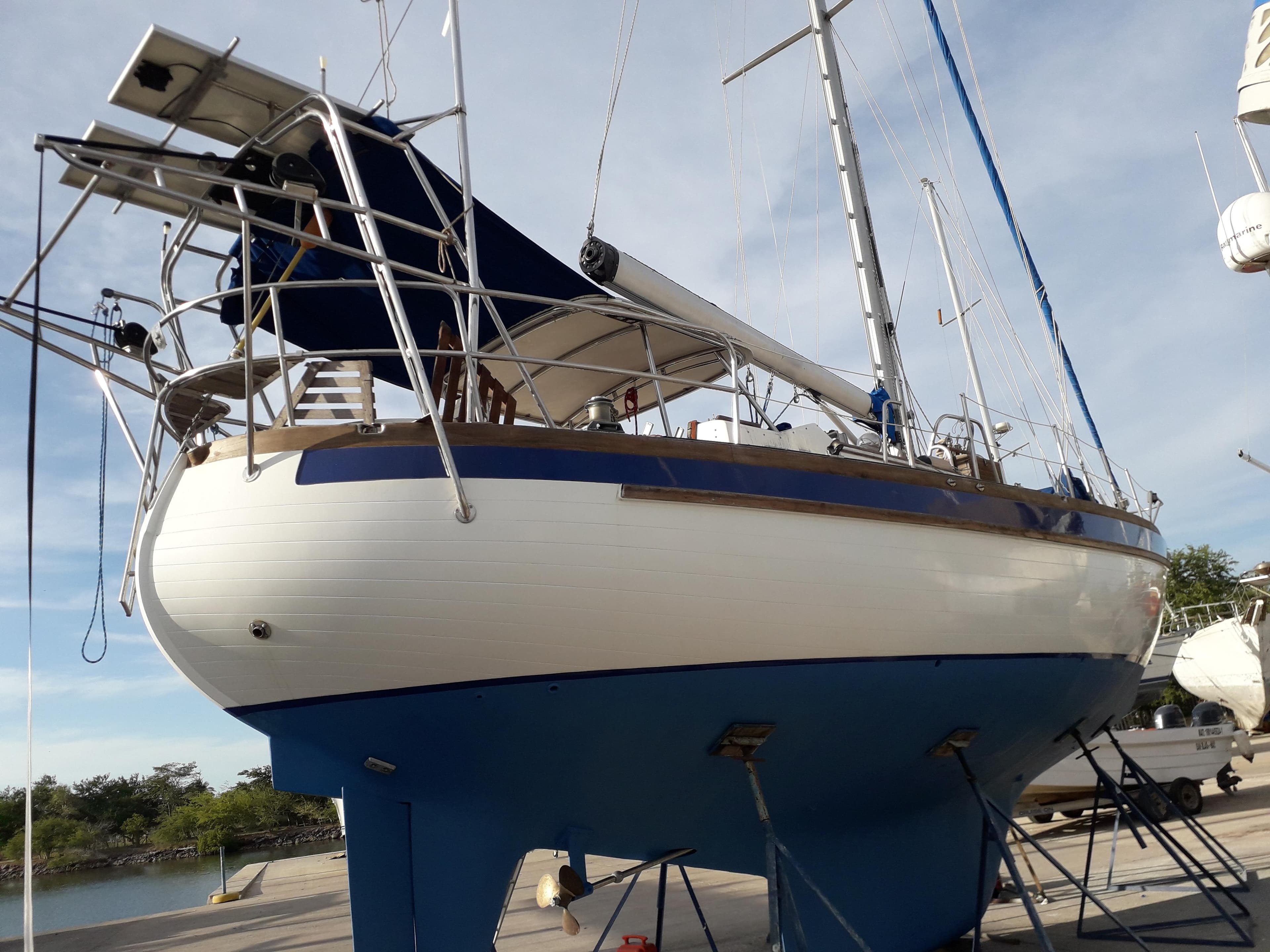 1986 Slocum 43 Cutter sailboat on dry dock, blue hull, white deck, clear sky background.