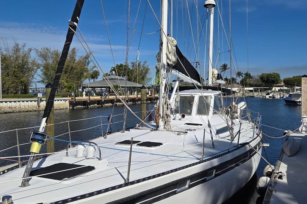 1982 Tayana Center Cockpit Cutter Ketch docked in a sunny marina.