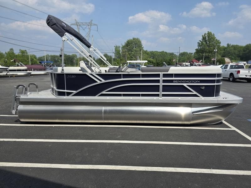 2025 Bennington 20 SL pontoon boat parked in a lot, featuring sleek design and modern amenities.