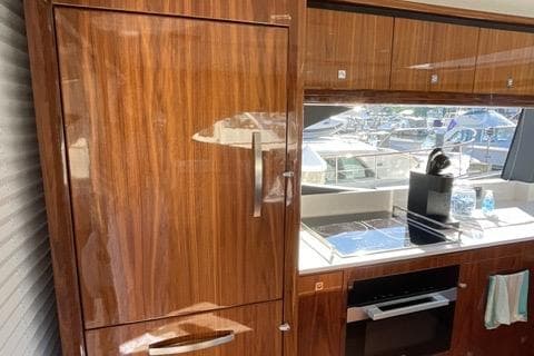 Luxurious interior of 2025 Riviera 585 SUV yacht with sleek wooden cabinetry.