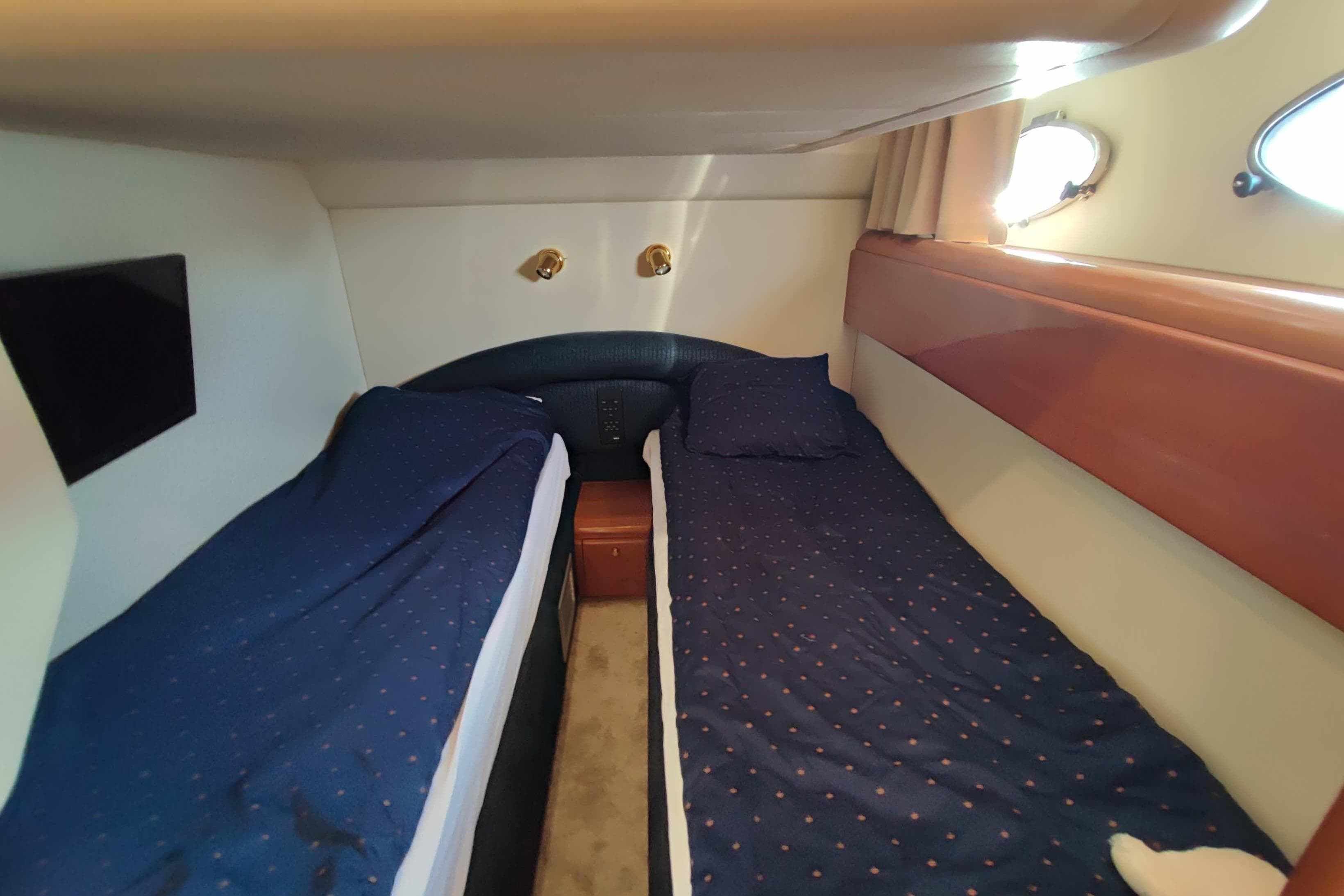 Twin cabin with blue bedding in 1998 Princess V55 yacht.