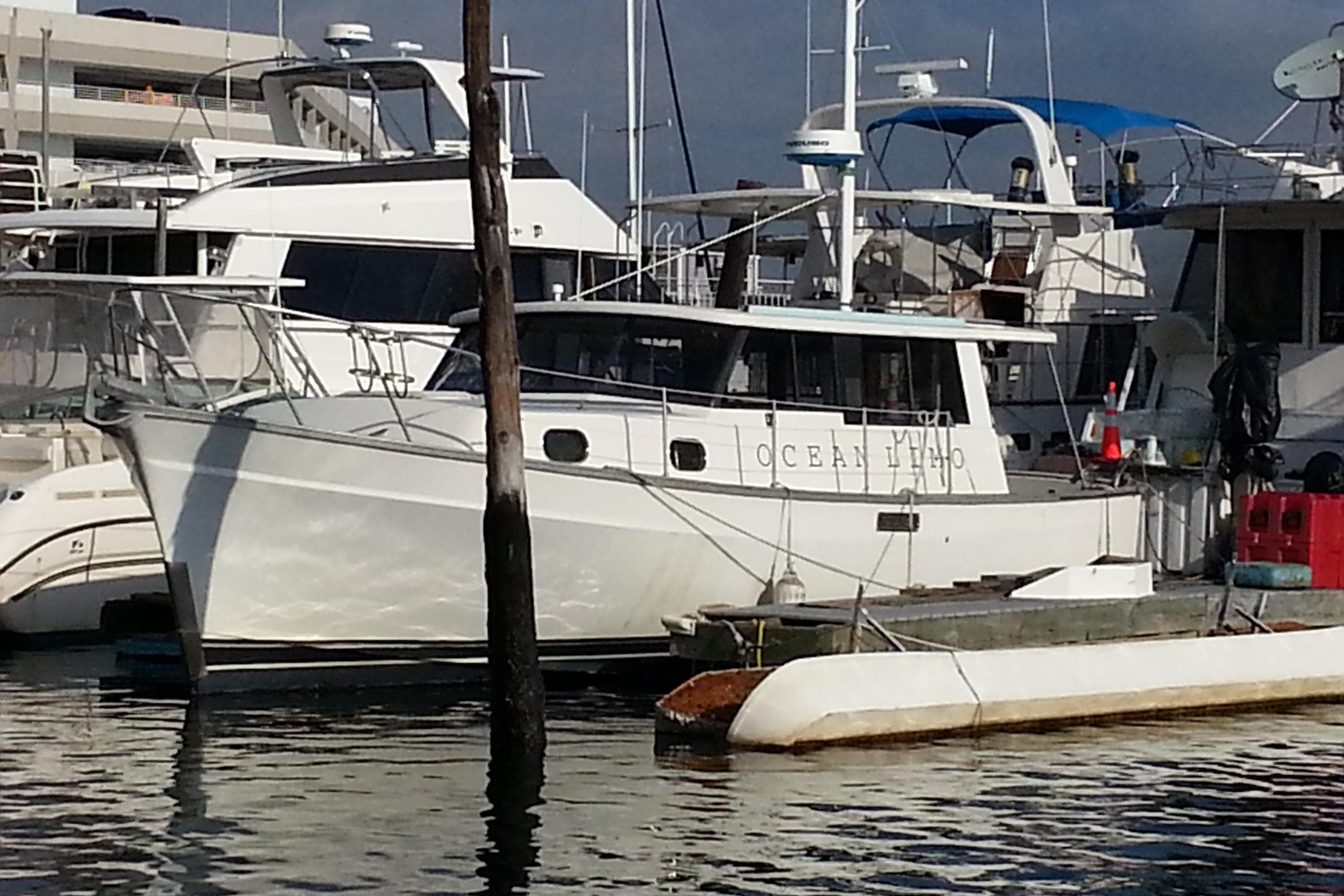 1979 Mainship 34 Custom Sedan docked at a marina, surrounded by other boats.