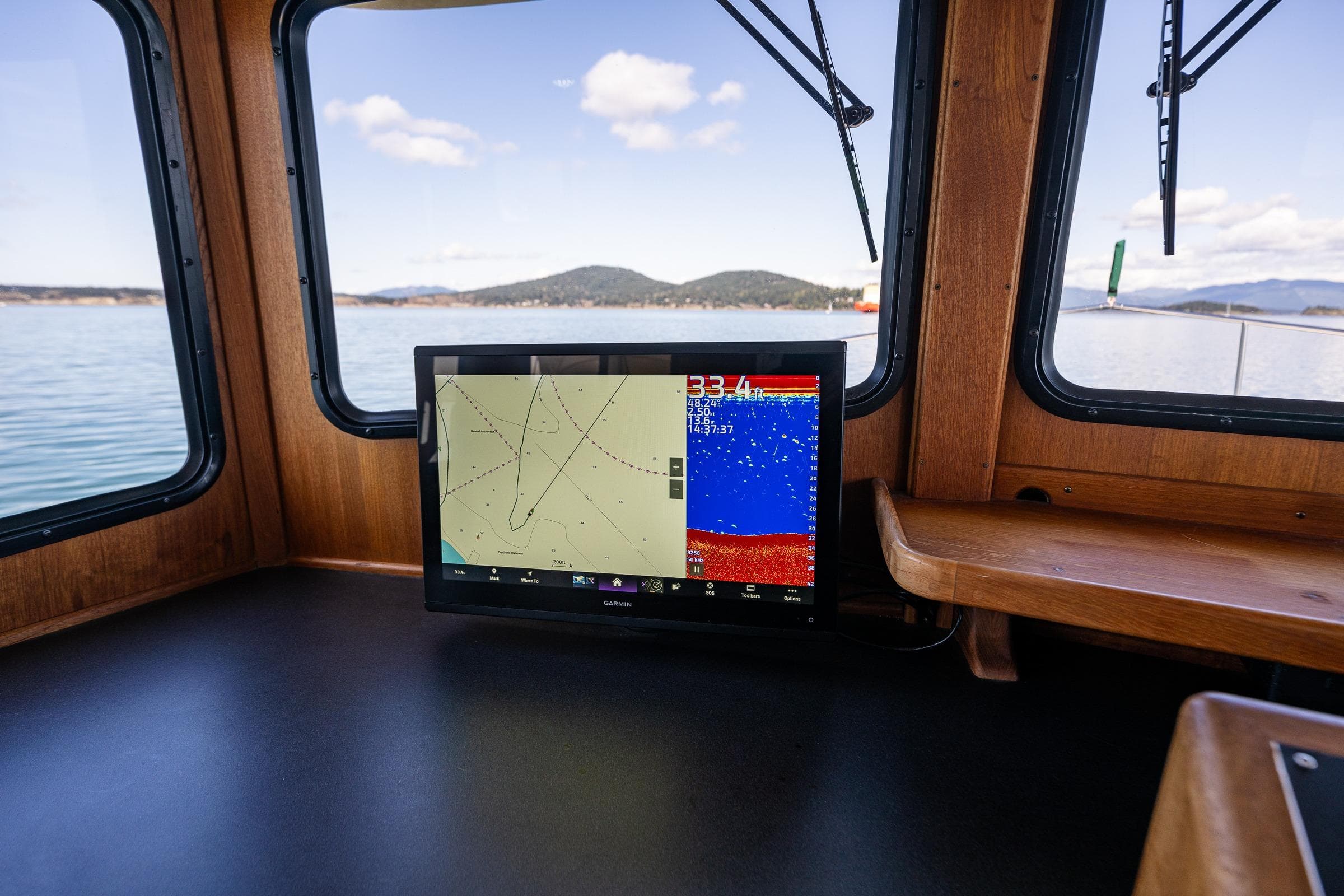 Navigation system inside 1997 Nordic Tug 42, with scenic water and mountain views.