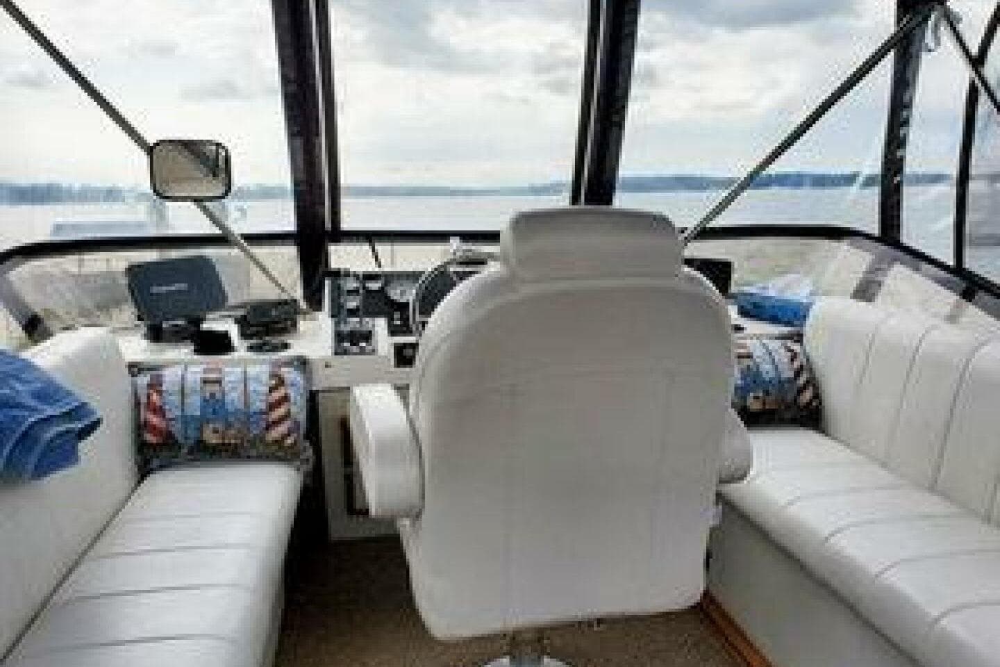 1986 Bayliner 3270 Motoryacht interior with white seating and panoramic water view.