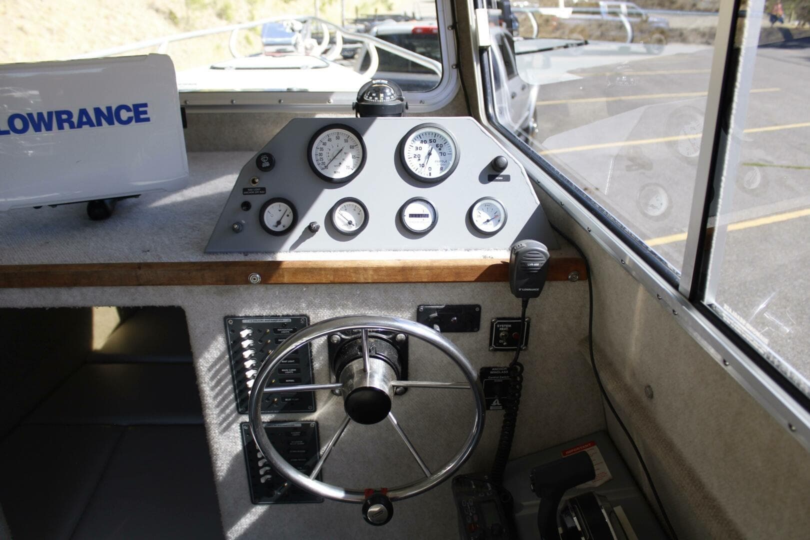 Steering console of a 2005 ACB 27 boat with gauges and controls.