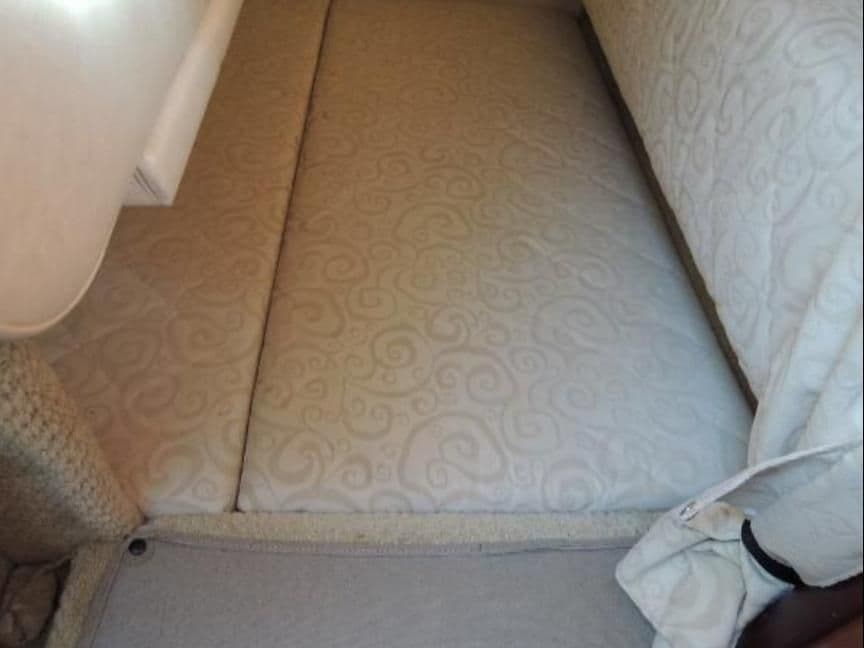 Interior of 2005 Sea Ray Sundancer 260 with cushioned bed.