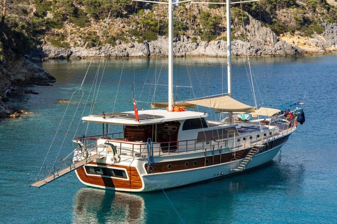 Luxurious 2022 Gulet 24m yacht anchored in a serene, picturesque bay.