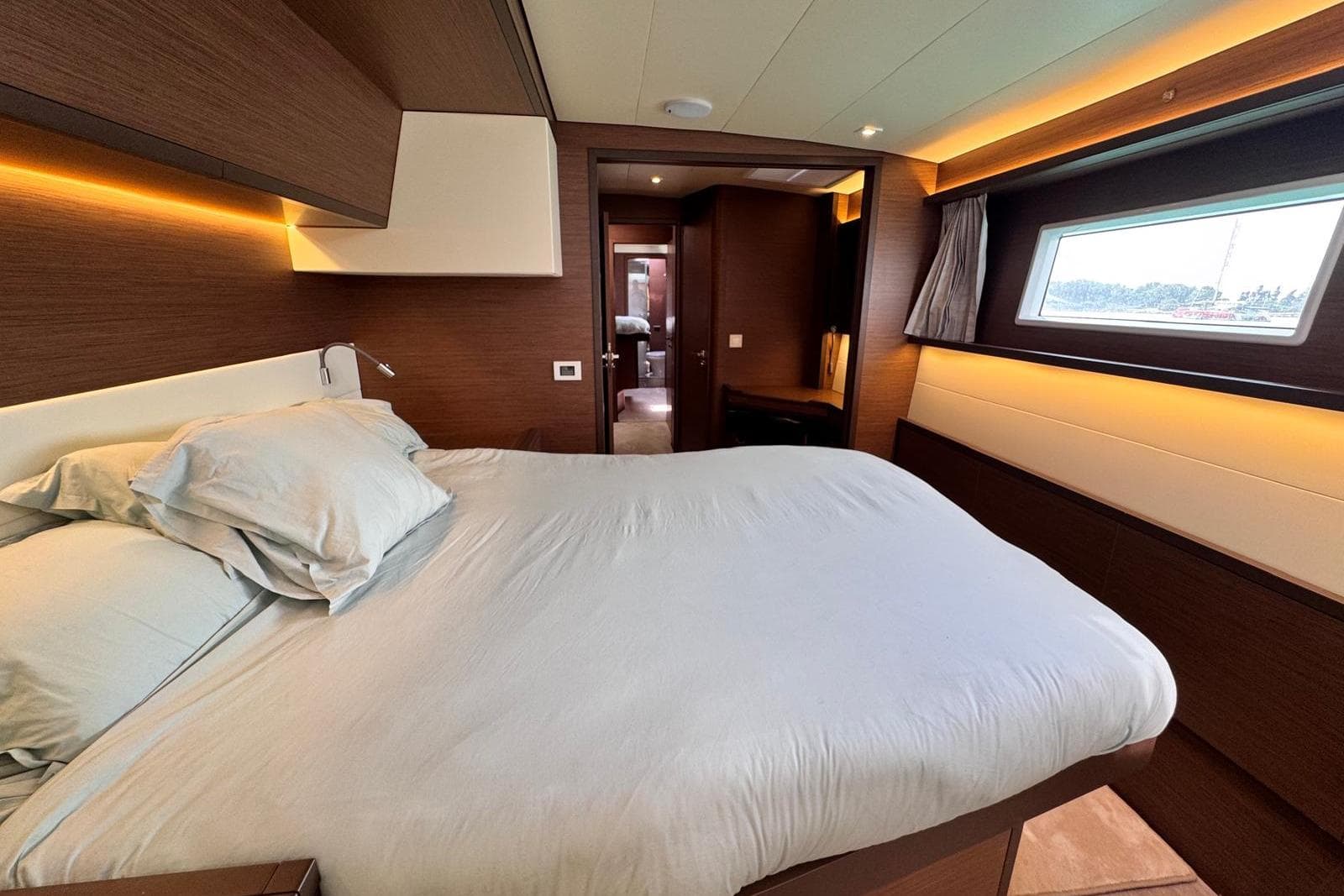 Luxurious bedroom interior of 2021 Lagoon 52 F yacht with modern design and ambient lighting.