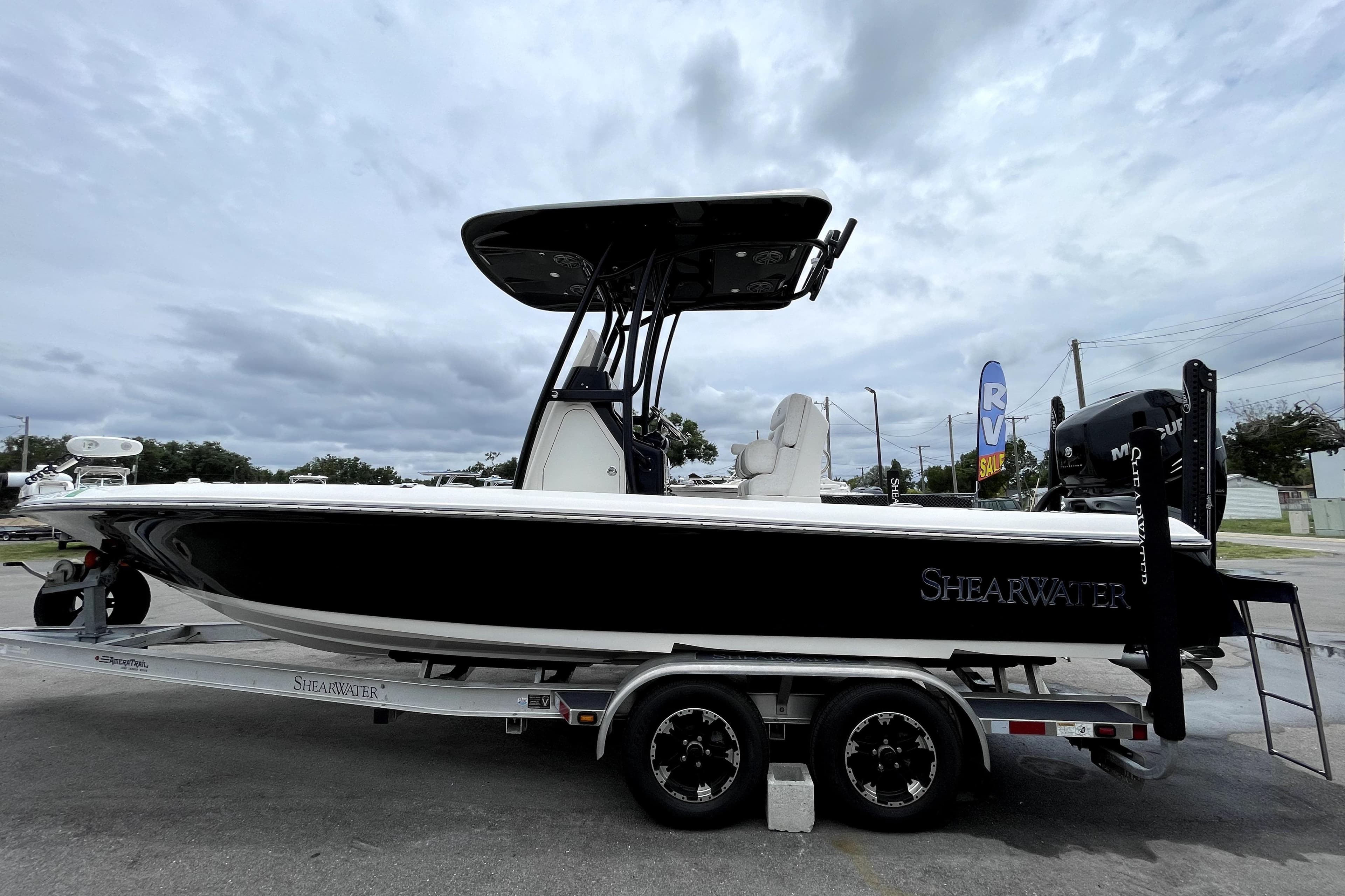 2019 ShearWater 25 LTZ boat on trailer under cloudy sky.