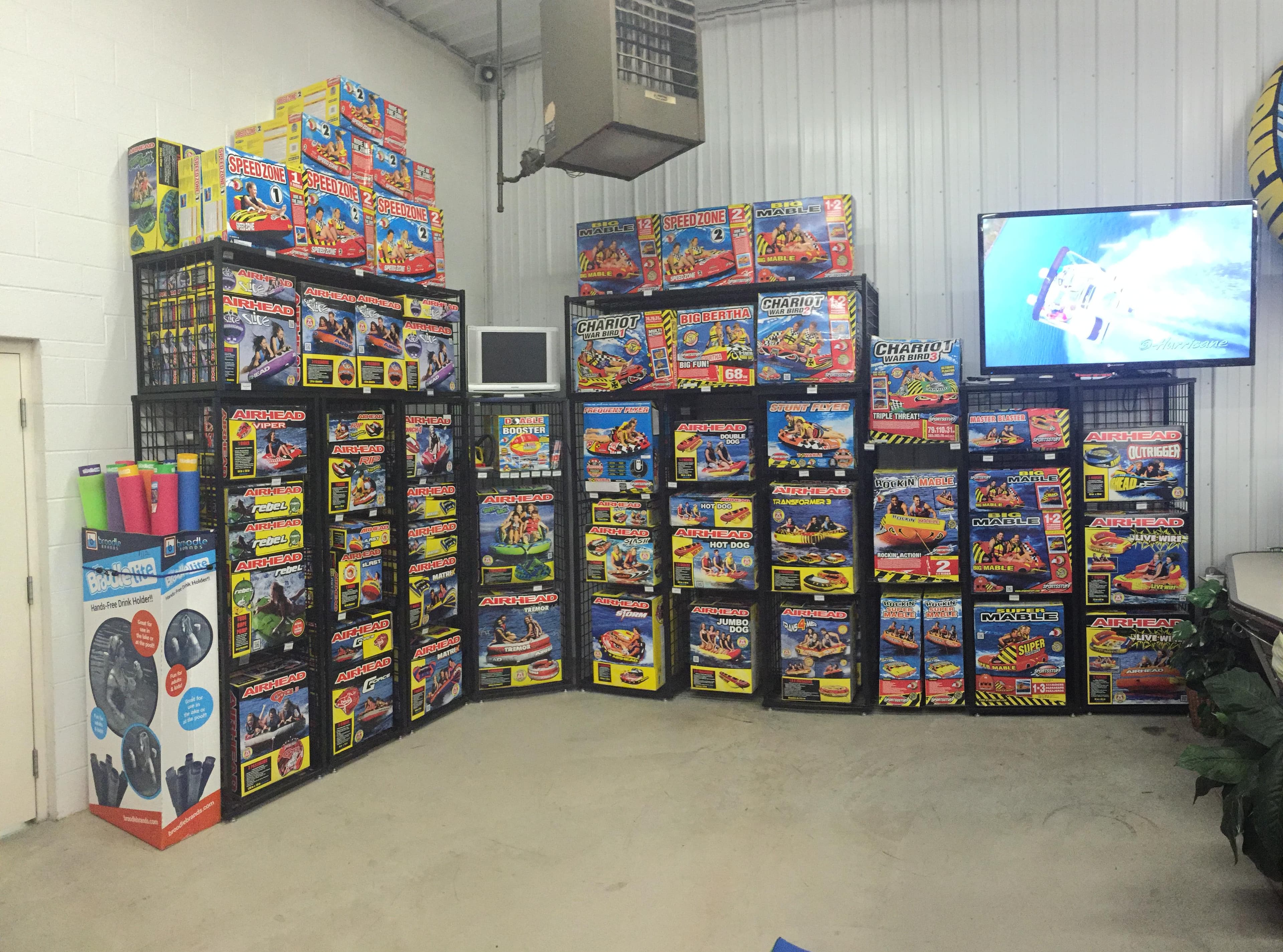 A room filled with colorful fireworks boxes and a TV displaying an image.