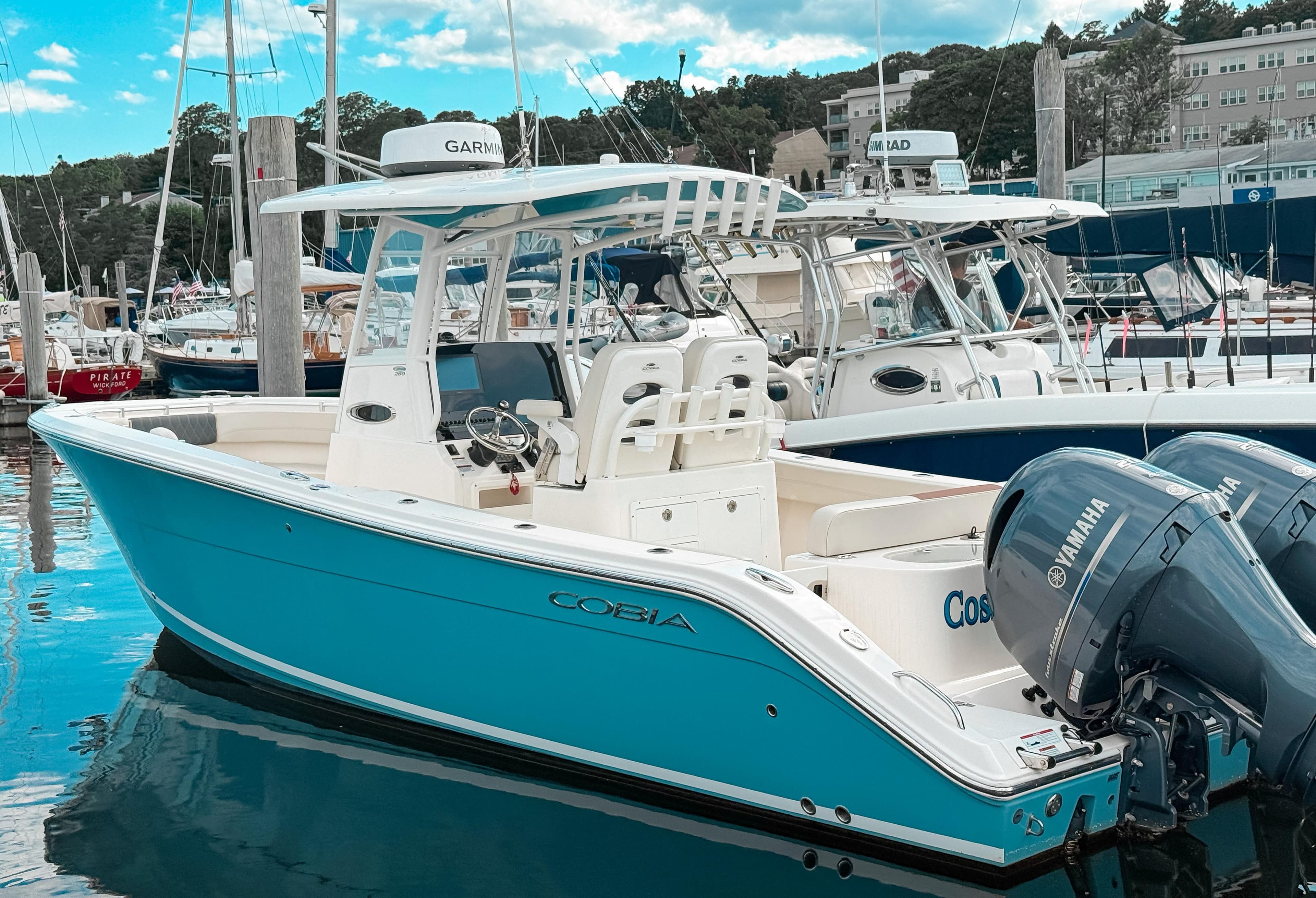 2023 Cobia 280 Center Console boat docked with Yamaha engines.