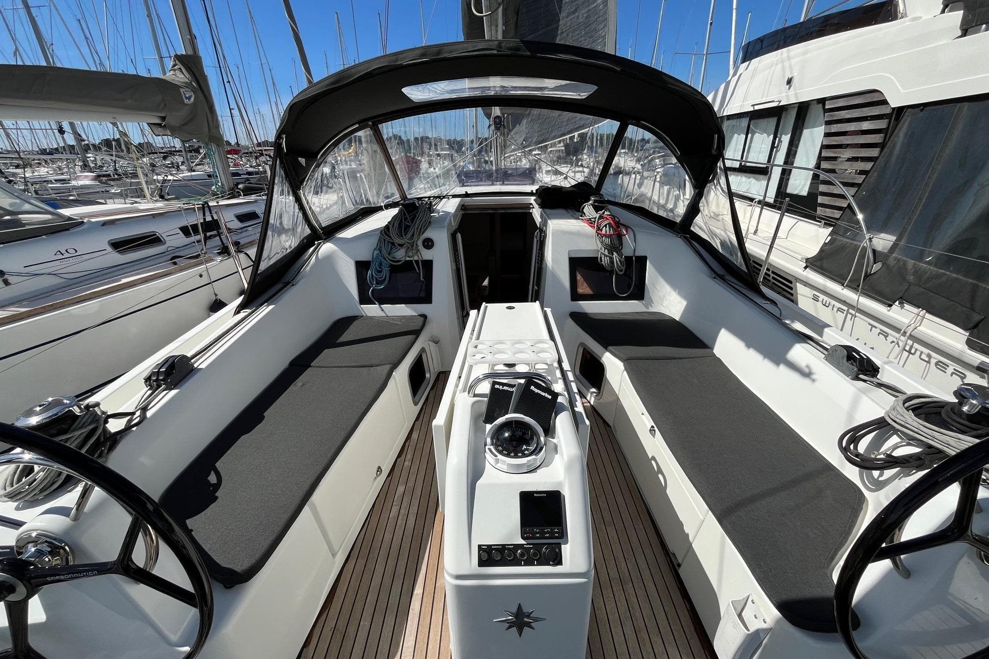 Cockpit of 2019 Jeanneau Sun Odyssey 410 sailboat, featuring dual steering wheels and spacious seating.