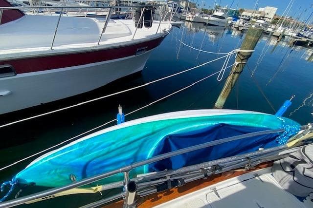 Blue kayak on Endeavour 40 sailboat, docked in marina, 1982 model.