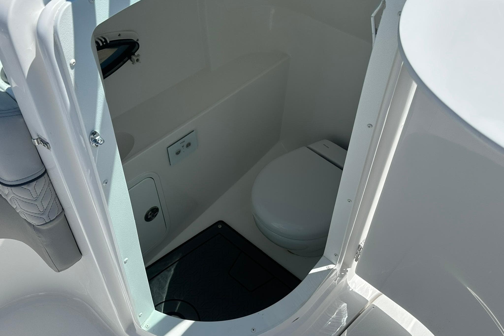 2026 Hurricane SunDeck 2400 OB boat interior with compact marine toilet.