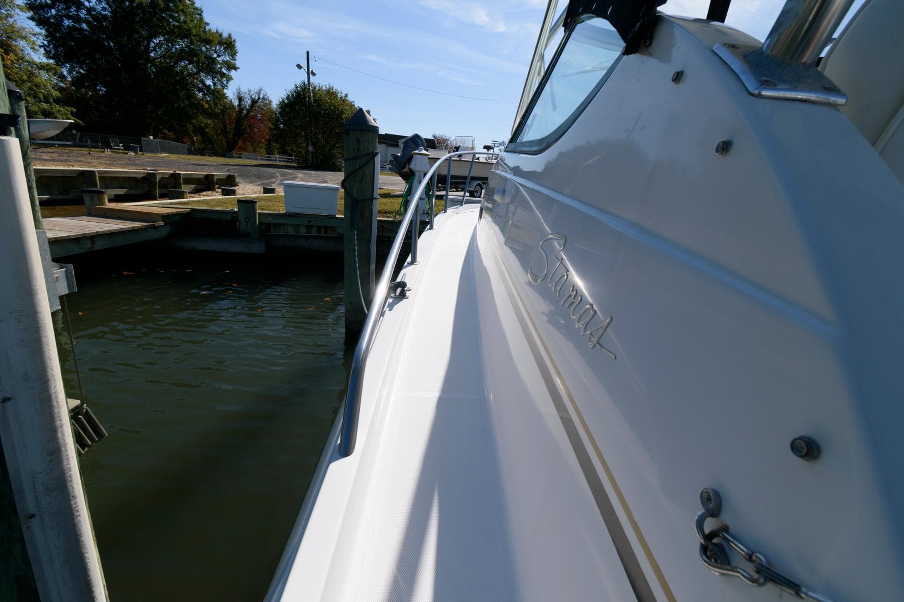 2005 Stamas 320 Express boat docked, featuring sleek design and Suzuki 350 repower.