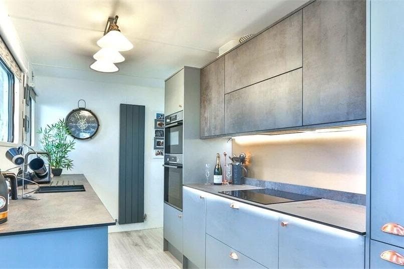 Modern kitchen interior on a 2007 houseboat, featuring sleek cabinetry and contemporary appliances.