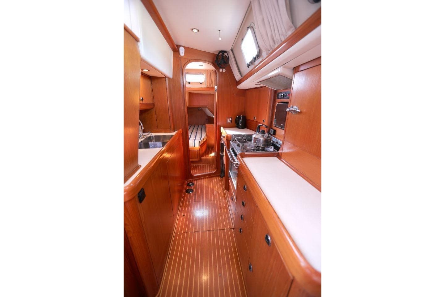 Interior of 1996 Nautor Swan 48 yacht, featuring a wooden galley and cozy cabin space.