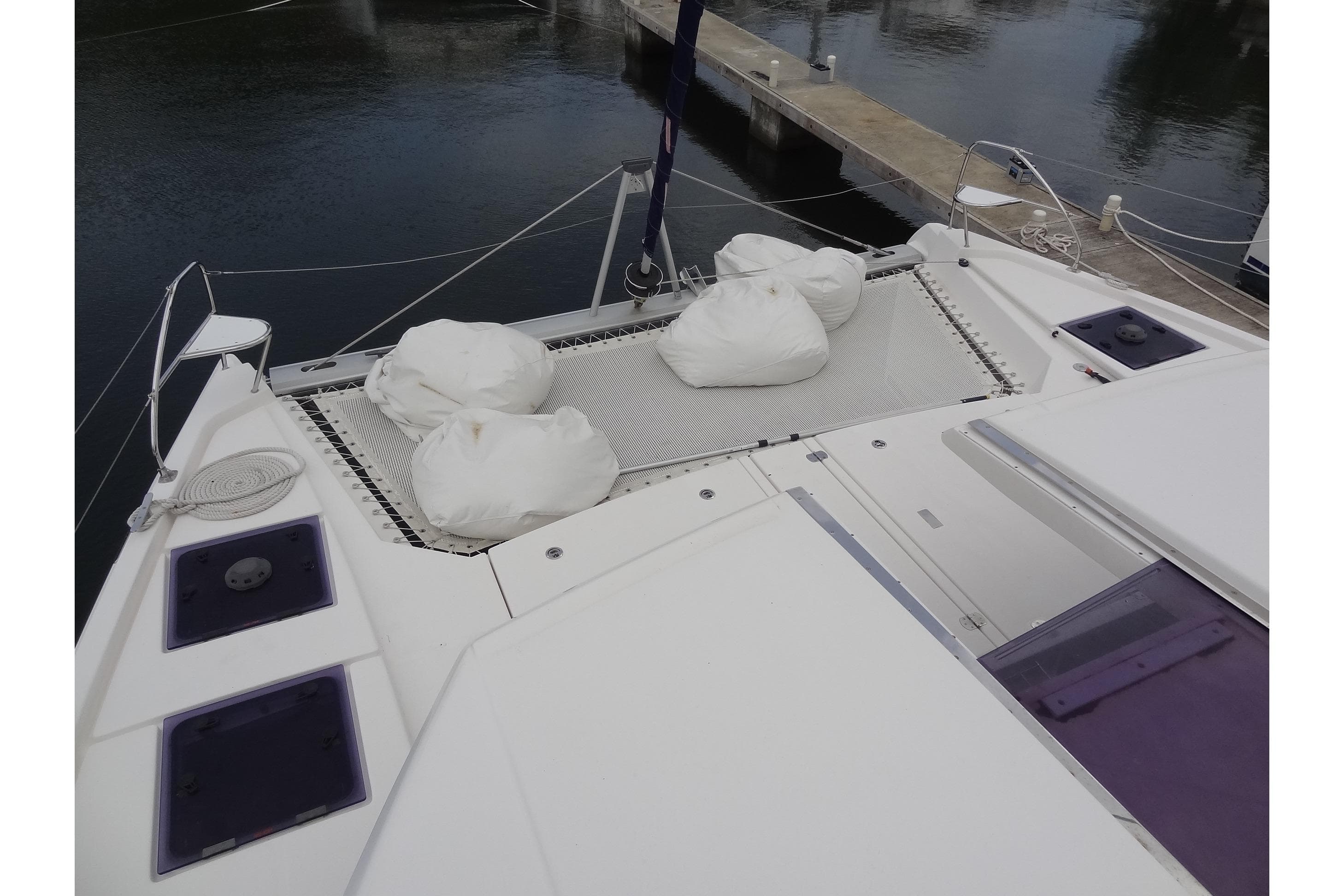 2020 Leopard 45 catamaran deck with netting and white bags at marina.