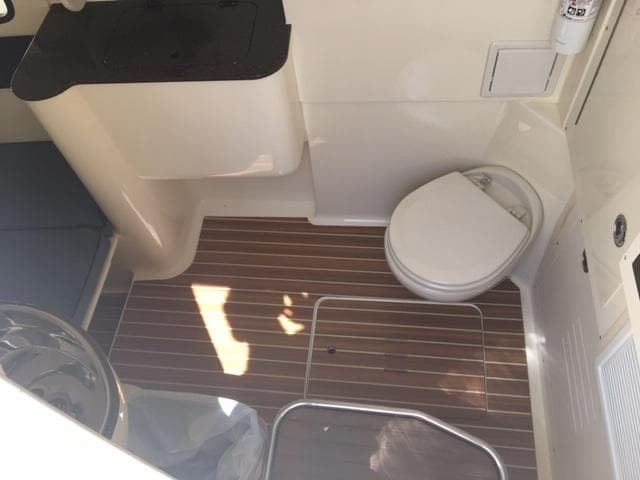 2016 Scout 350 LXF boat interior with toilet and wooden flooring.