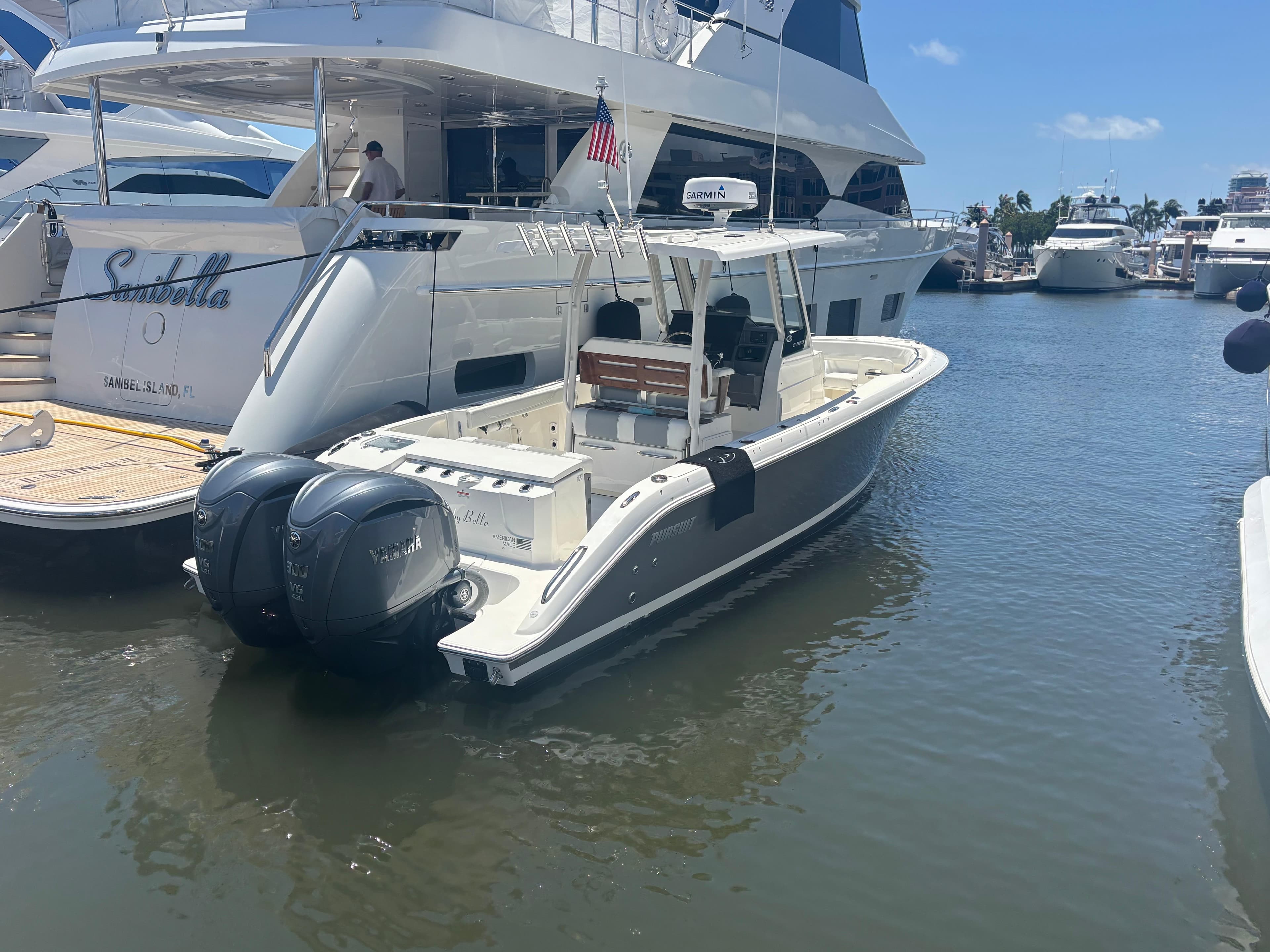 2022 Pursuit S 288 boat docked in marina with twin outboard engines.