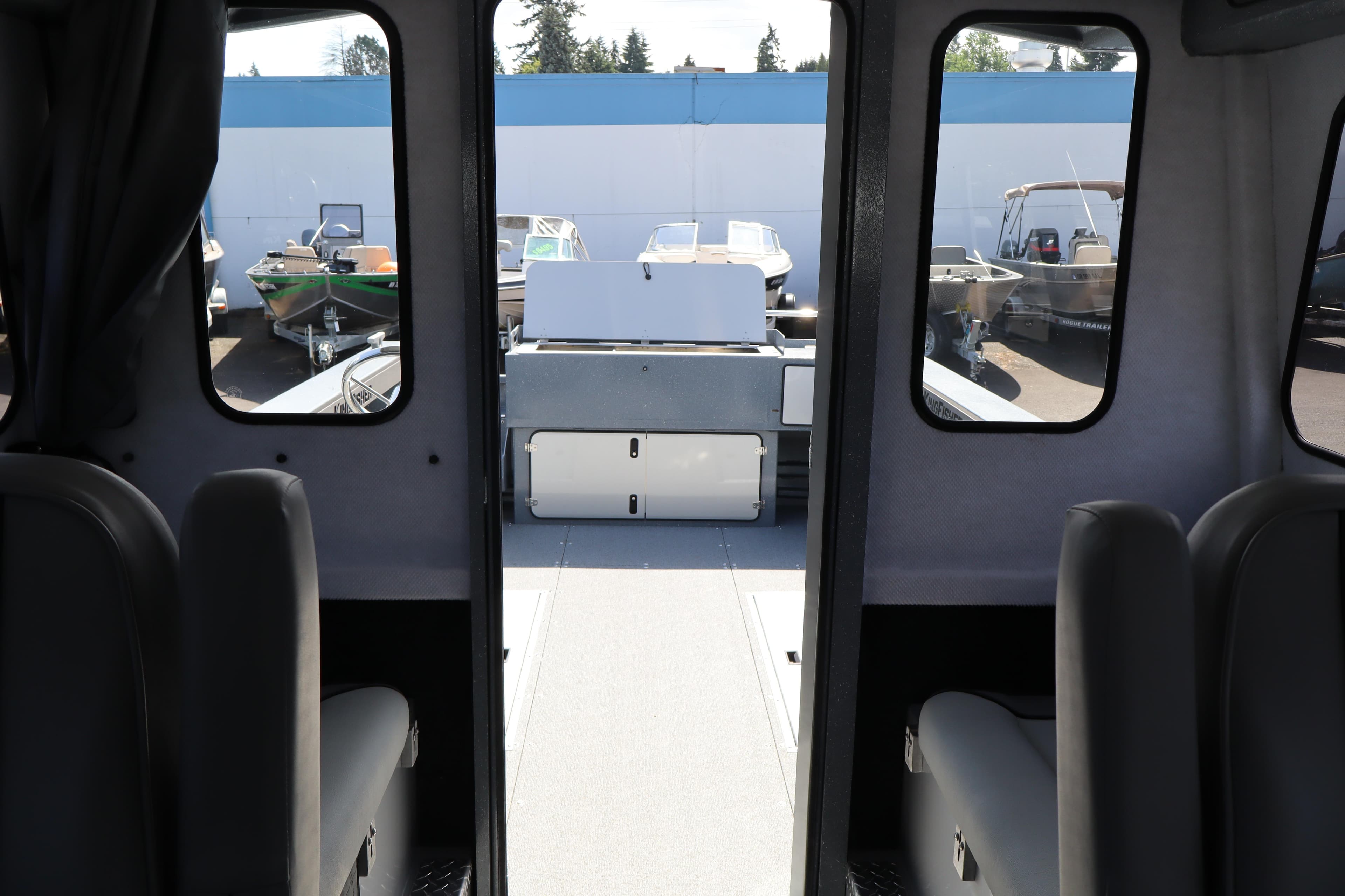 Interior view of 2026 KingFisher 2825 Coastal Express boat, showcasing seating and windows.