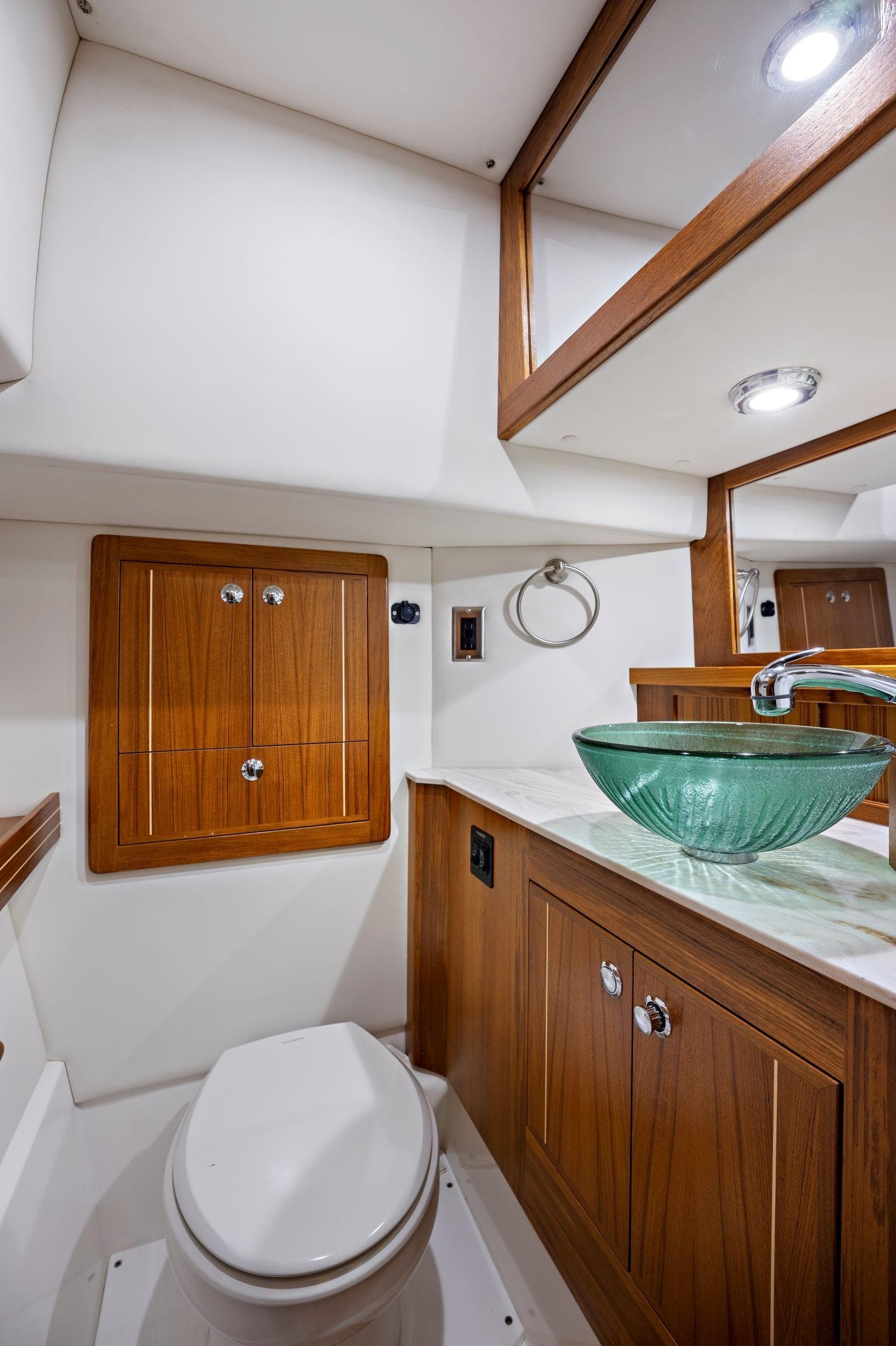 Luxurious Aspen C100 2026 yacht bathroom with wooden cabinetry and glass vessel sink.