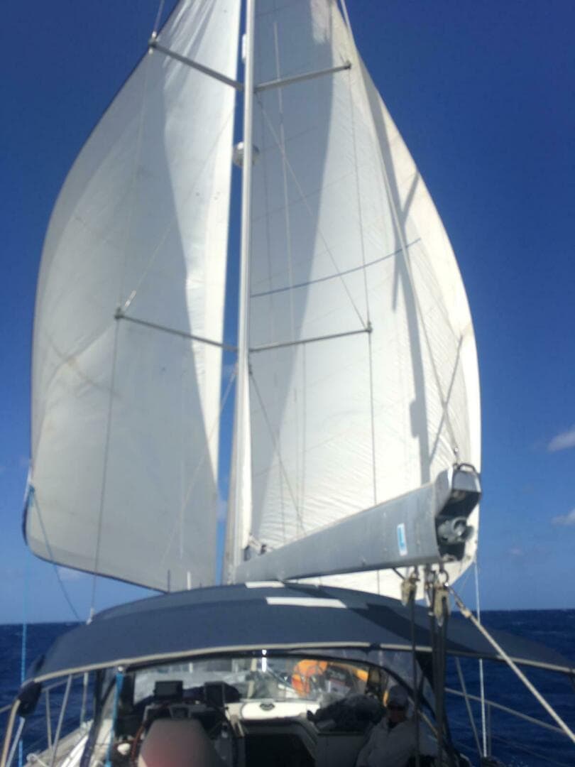 Sailing yacht Beneteau 57, 2009 model, with full sails against a clear blue sky.