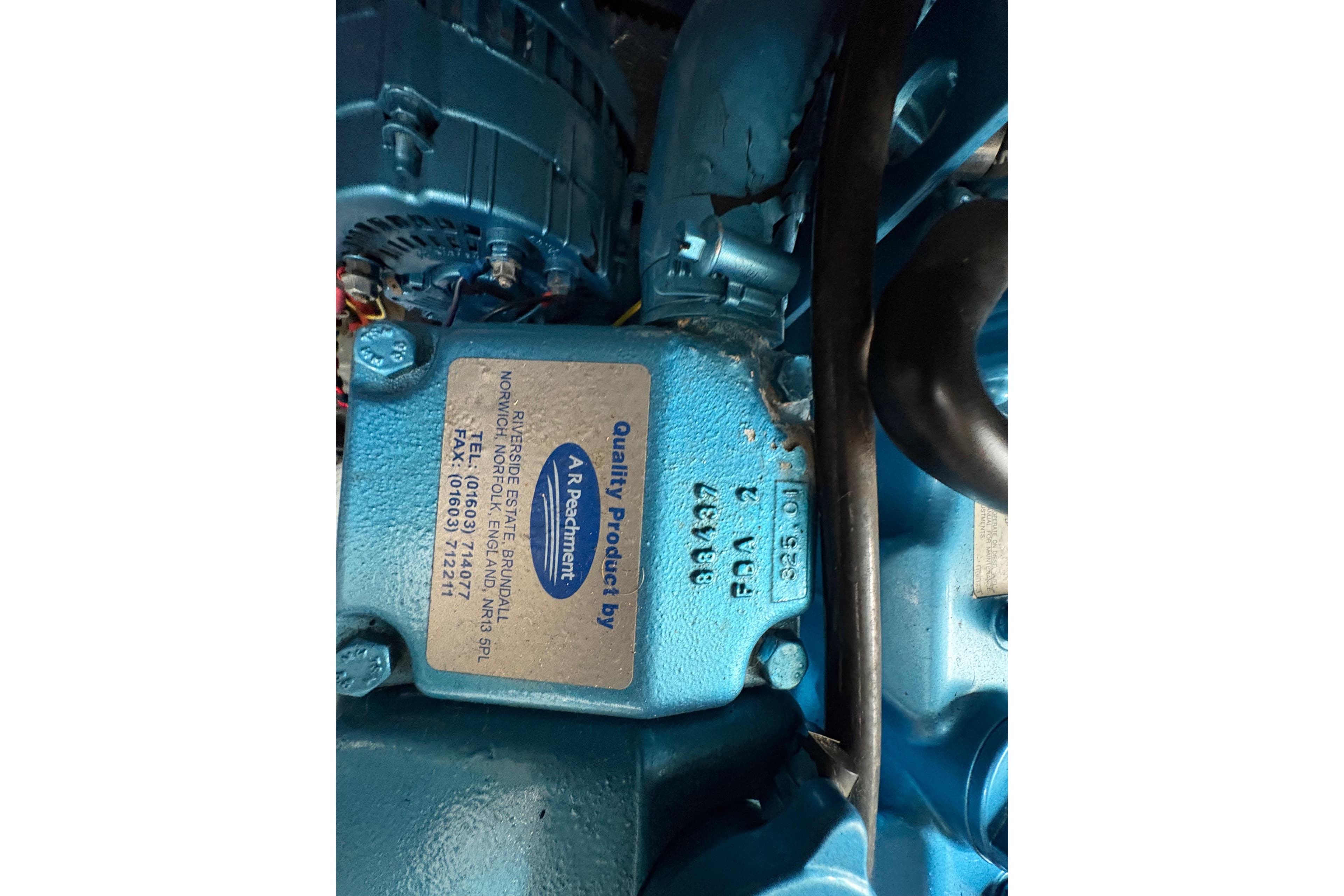 Close-up of a blue Capriole 900 engine part with label, 2002 model.