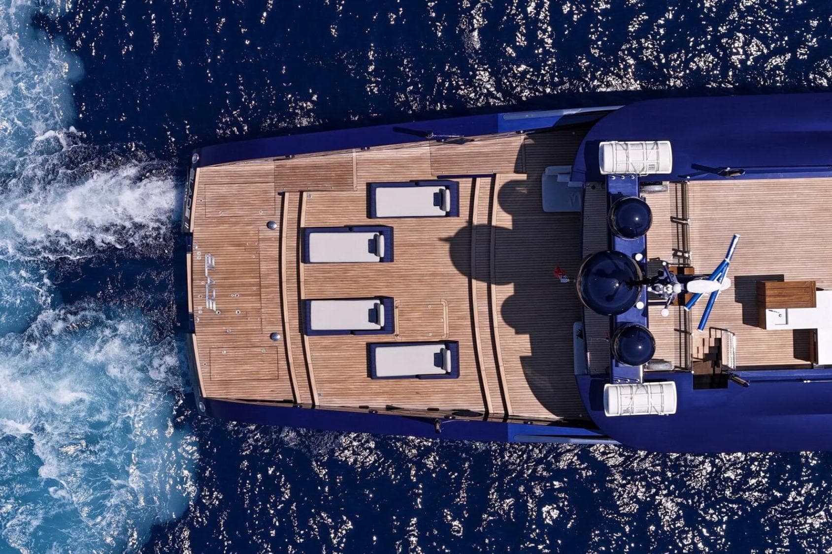 Aerial view of 2009 MMGI 44m yacht cruising on blue ocean waters.