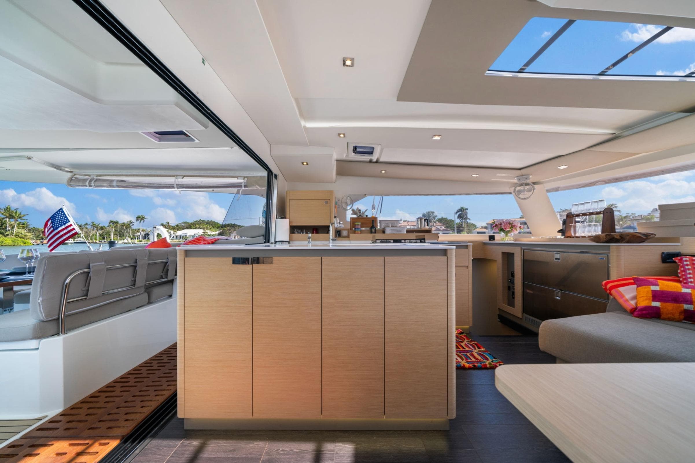 Luxurious interior of 2024 Fountaine Pajot Aura 51 Catamaran with modern kitchen and seating area.