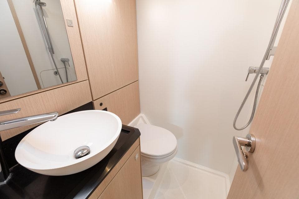 Modern bathroom in 2023 Jeanneau 60 yacht with sleek sink and shower.