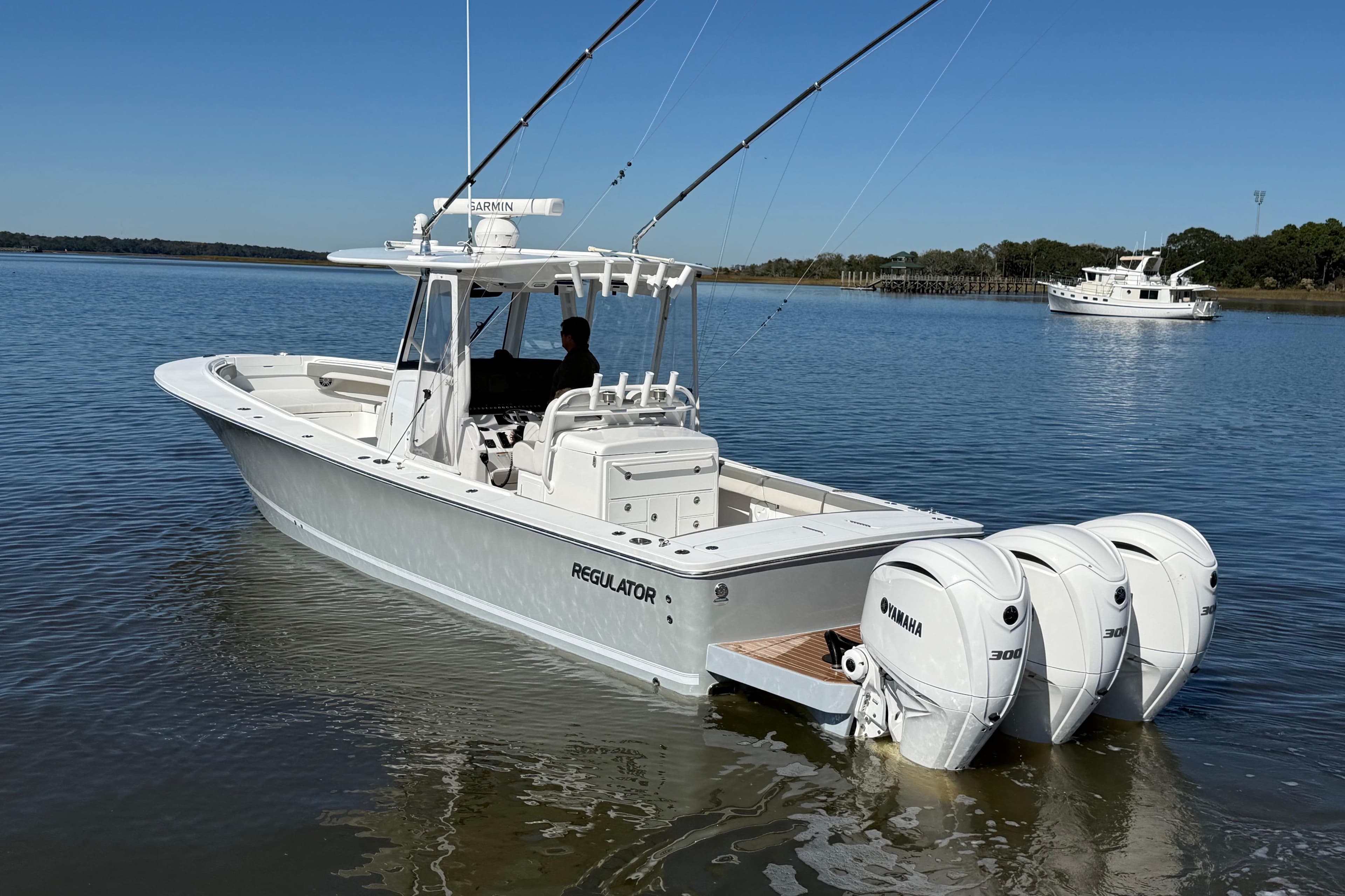 2022 Regulator 34 boat with triple Yamaha engines on calm water.