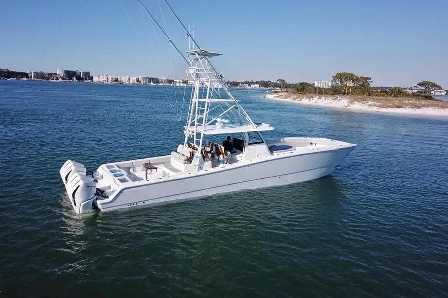 2023 Freeman 47 boat cruising on calm waters near a sandy shoreline.