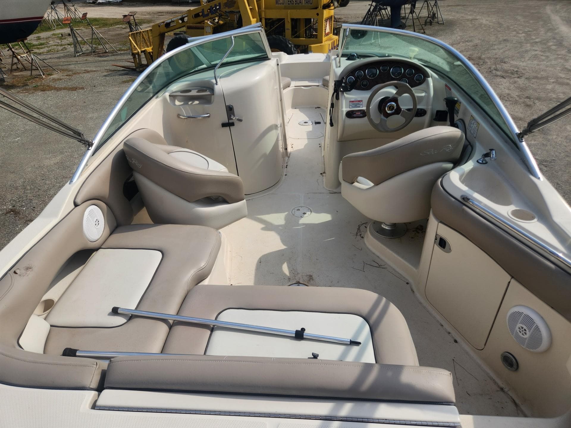 2003 Sea Ray 220 Sundeck boat interior with beige seating and steering console.