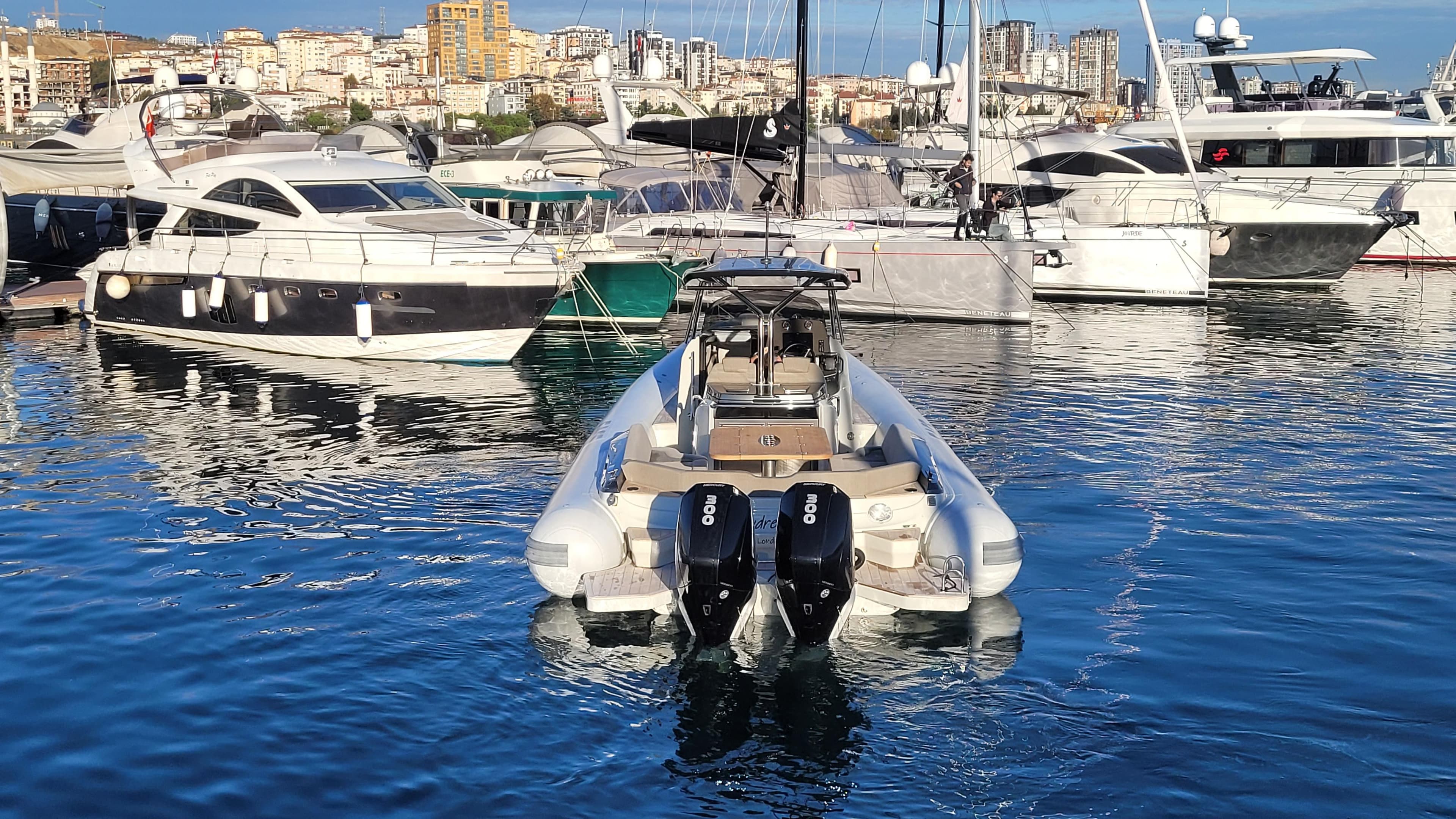2022 SACS Strider 11 in harbor, surrounded by yachts.