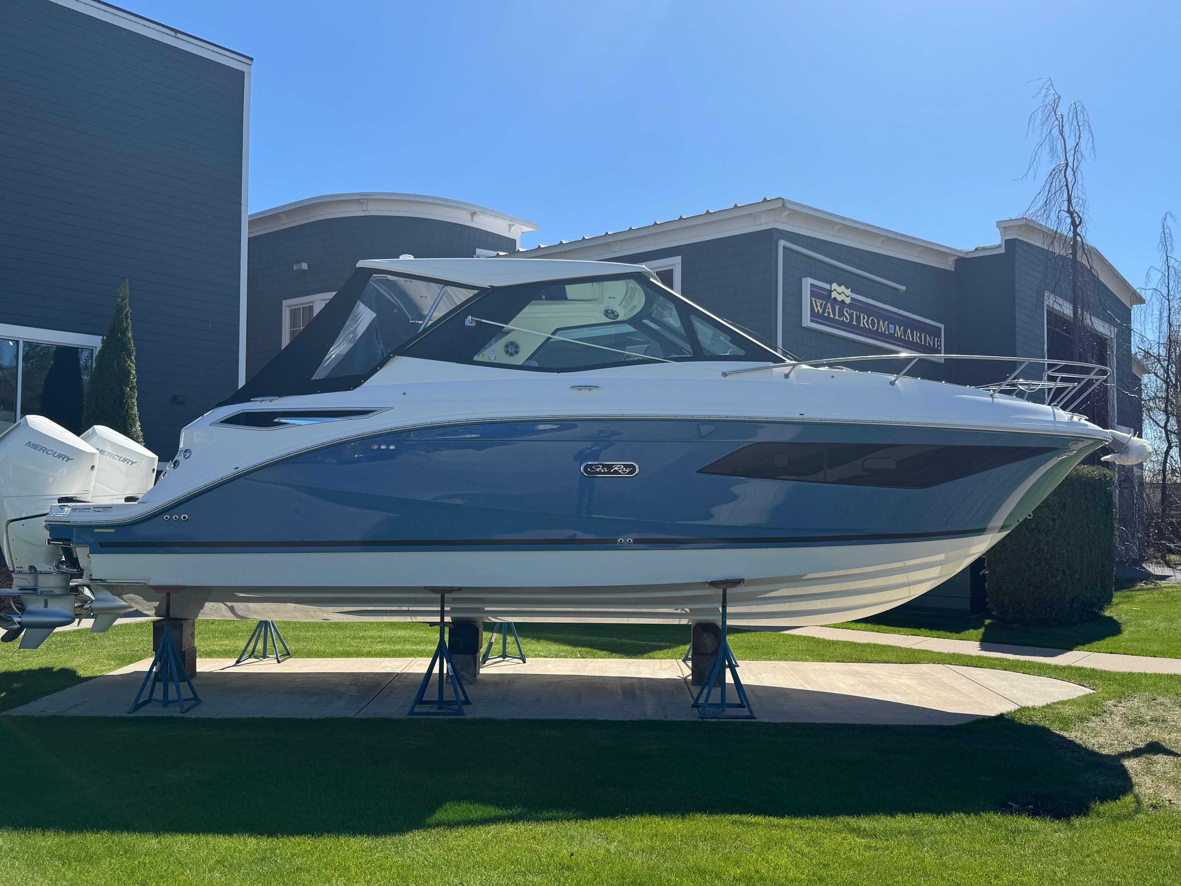 2025 Sea Ray Sundancer 320 Coupe displayed outdoors on stands.