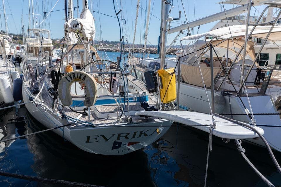 1982 Nautor Swan 65 sailboat "EVRIKA" docked at a marina, surrounded by other boats.