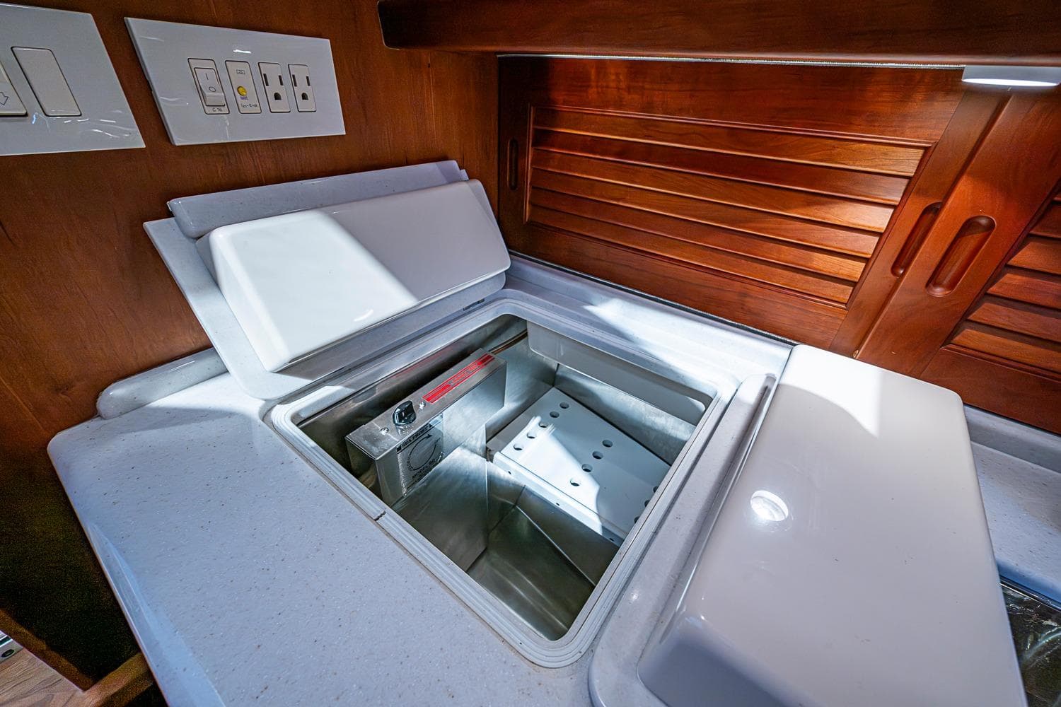 Interior of 2012 Hinckley Runabout 38 showing a built-in cooler and wooden cabinetry.